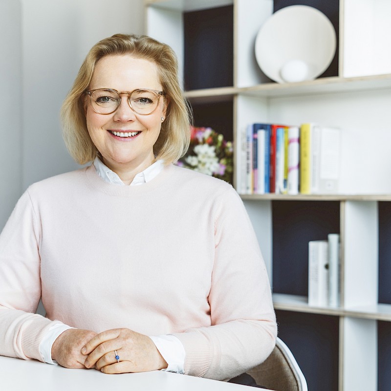 Ragnhild Struss im Büro vor einem Bücherregal